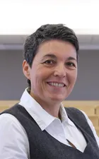 Foto von Frau Anguela: kurze Haare, lächelnd und ohne Brille